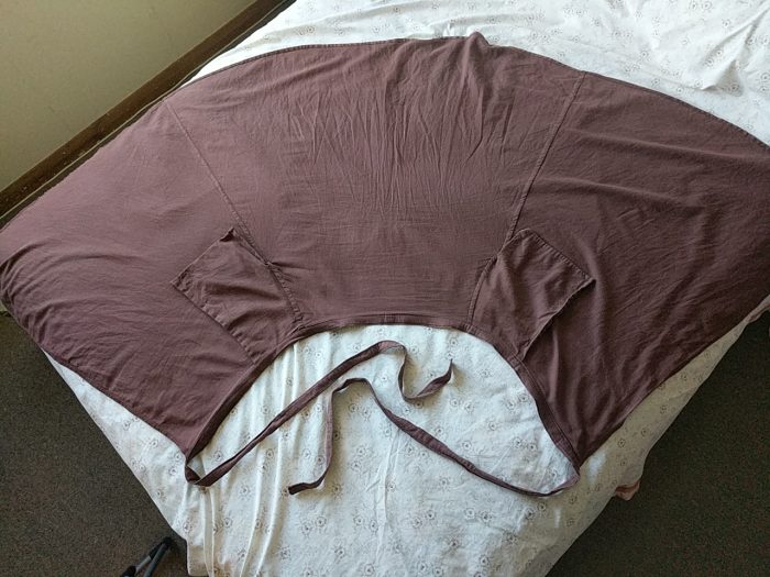 A wrap skirt laid out flat on a bed, wrong side showing. There are pockets at each seam, overlapping the front pieces of the skirt. 