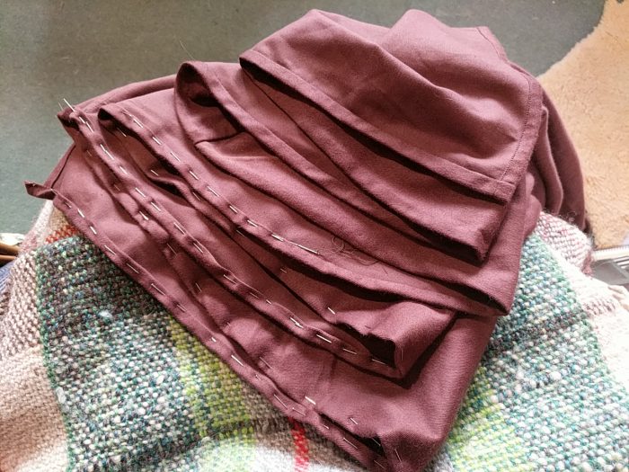 A wrap skirt folded in zig-zags to reveal the hem, partly pinned and partly sewn.