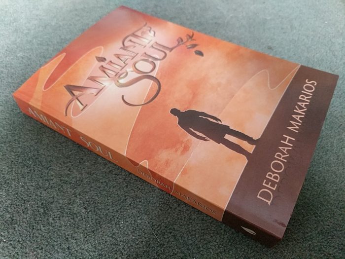 Photo of Amiant Soul paperback. The cover appears to have less yellow in its tones than the ebook cover does, and is a softer look overall.