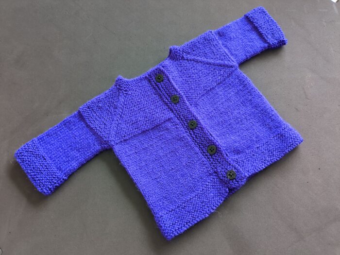 A vibrant purple 4ply baby cardigan with garter stitch trim and five buttons down the front.